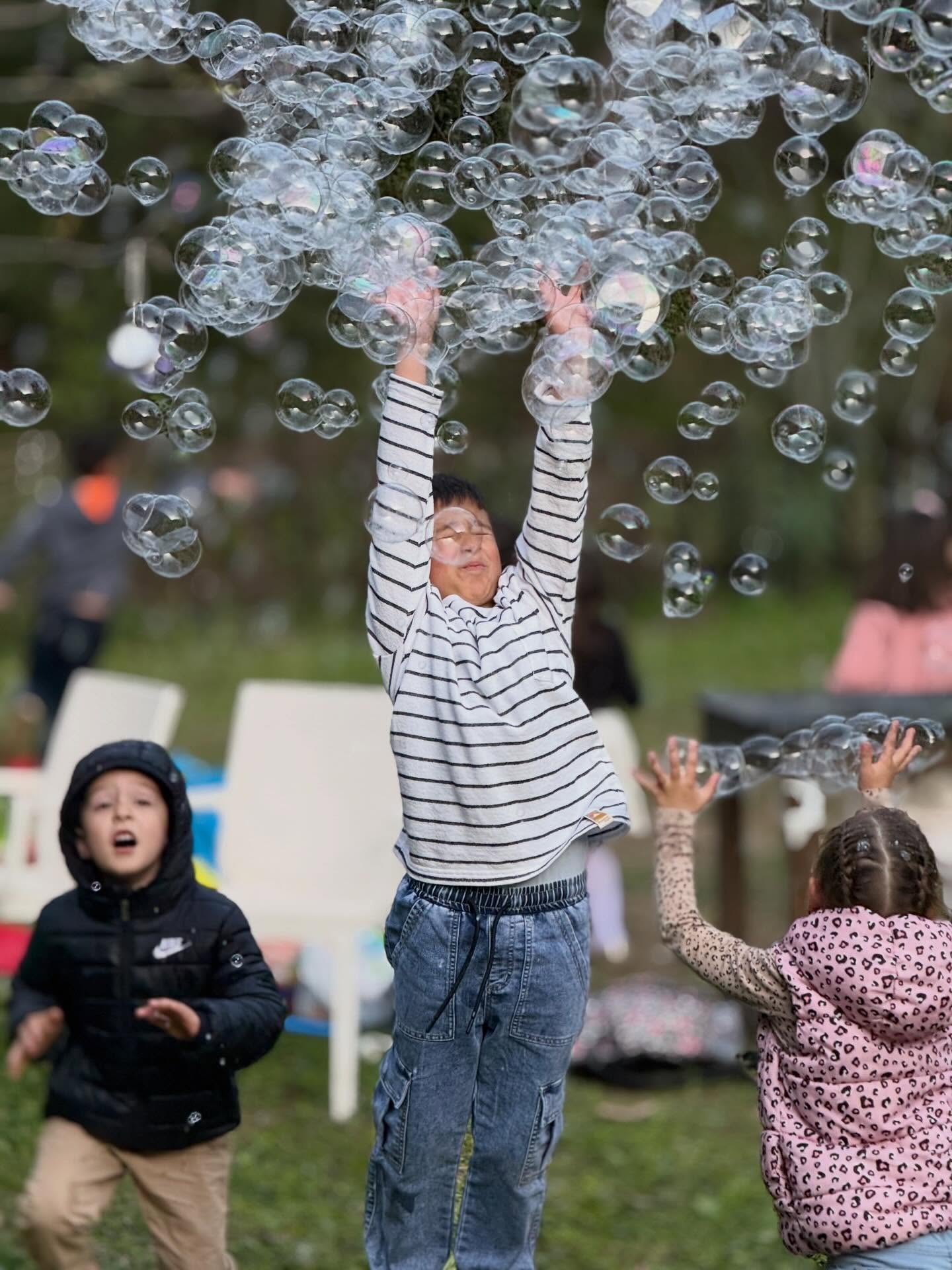 Children reaching for bubbles